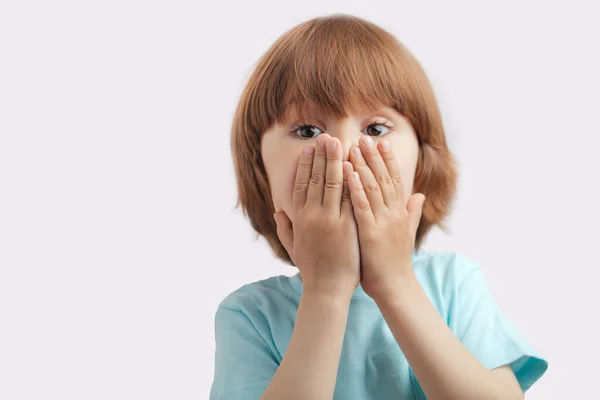 Rädd pojke stänger munnen med händerna — Stockfoto