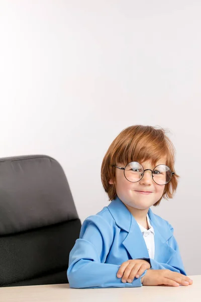 Niño sonriente con el pelo rojo descansando en la silla — Foto de Stock