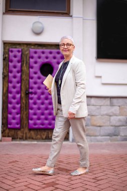 Başarılı şirket patronu modern iç mimariyle sokaklarda yürüyor.