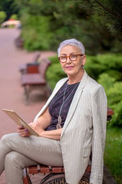 Aktif yetişkin bir kadın kameraya bakıyor.