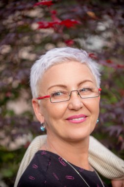 Kısa saç stili ve parlak makyajlı olgun bir kadının kesilmiş fotoğrafını çek.