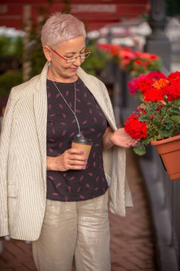 Modern kahve dükkanının iç kısmında duran muhteşem bir iş kadını.