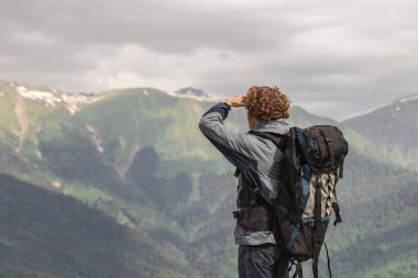 Dağcılık konsepti. Maceracı adam yolunu arıyor.