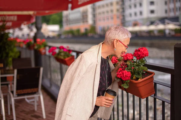 Vistitor av caféet luktar vackra röda blommor — Stockfoto