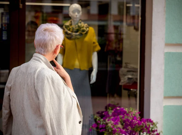 Cerrar vista posterior foto de la mujer pensativa de pie frente a la tienda — Foto de Stock