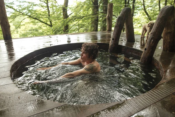 Junge gut aussehende Männchen nimmt ein Bad im Whirlpool — Stockfoto