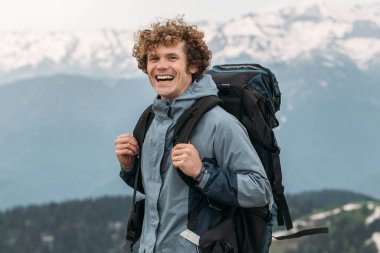 Tepede gülen sırt çantalı