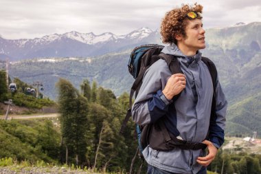 Güzel görünümlü turist dik, yüksek dağda duruyor.