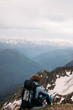 Yalnız, dikkatsiz bir adam kayanın ucunda.