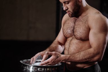 Sakallı, brytal kaslı, magnezyumlu adamın kesilmiş yan görüntüsünü kapat.