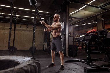 Hırslı vücut geliştirici vuruşlar, tekmeler, vuruşlar yapıyor.