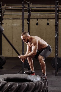 Amatör vücut geliştirici çekiç darbesi yapıyor.