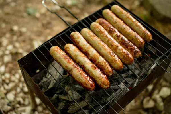 Close up photo of preparation of sausages on barbecue grill — Stock Photo, Image