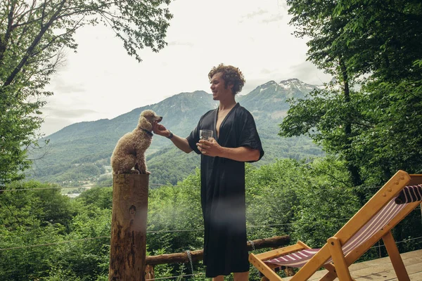 Блондин играет с собакой во время отдыха в отеле с террасой — стоковое фото