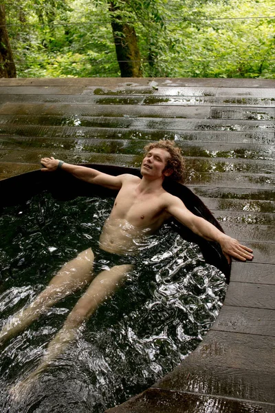 Piacevole ragazzo sta meditando nella vasca da bagno con acqua fredda dopo stabilimento balneare — Foto Stock