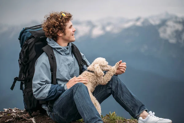 人和他的狗欣赏群山的景色，望着远方. — 图库照片