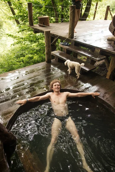 Homem alegre é refrescante em água fria após sauna quente — Fotografia de Stock