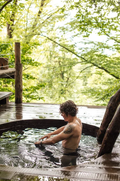 Hombre deportivo está haciendo ejercicio en el agua mientras se baña — Foto de Stock