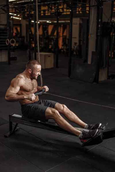 Strength , power and force concept. intense exercise on rowing machine — Stock Photo, Image