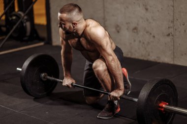 Spor salonunda halterli düşünceli güçlü bir sporcu.