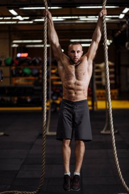 Tam boy portre. Vahşi fitness adamı halatlarla atlayacak.