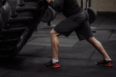 Kesilmiş fotoğraf. Erkekler atölyede bacaklarını geriyor.