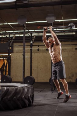 Çekiçli sporcu vurabildiği kadar sert vurmaya çalışıyor.