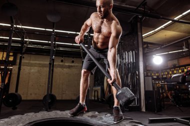 Vahşi adam çekiçle ısınıyor.