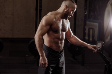 Vücut geliştirici, vücut çalışmanın inatçılığını düzenliyor.