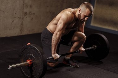 Genç hırslı zinde adam halteri kaldıracak.