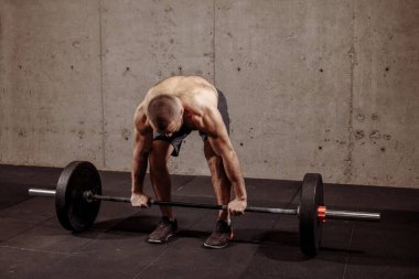 Genç sporcu spor kulübünde ağırlık antrenmanı yapıyor.