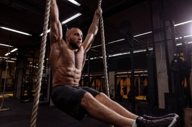 Genç hırslı zinde bir adam vücudunu L formunda tutuyor.