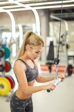 Spor merkezinde en son sırada egzersiz yapan sağlıklı bir kadın.