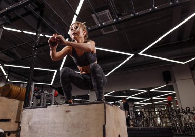 Zıplama egzersizi yapan genç ve hırslı bir kadın..