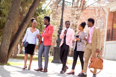 İş adamları kahveyle yürüyor.