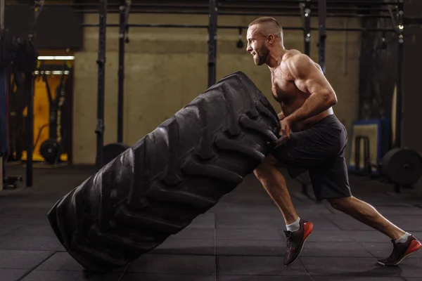 Jeune sportif ambitieux se concentre sur son entraînement avec des pneus lourds — Photo