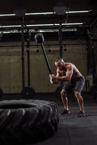 Brutal kille naken till midjan hamrar enorma däck på gym — Stockfoto