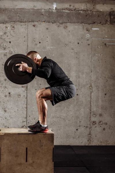 Sportif kıyafetli yetenekli sporcu halter levhalarıyla çömeliyor. — Stok fotoğraf