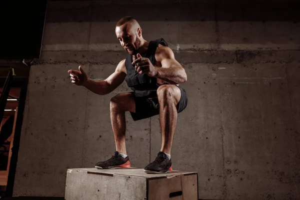 Gars à la salle de gym travaillant debout sur une boîte à squat en bois. — Photo