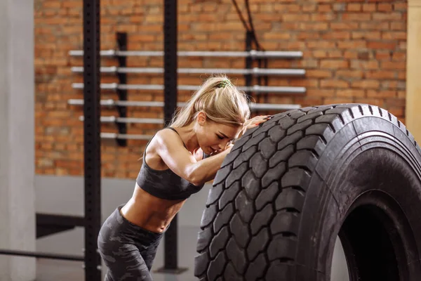 Menina fitness atraente está construindo força durante o treinamento cross fit. — Fotografia de Stock