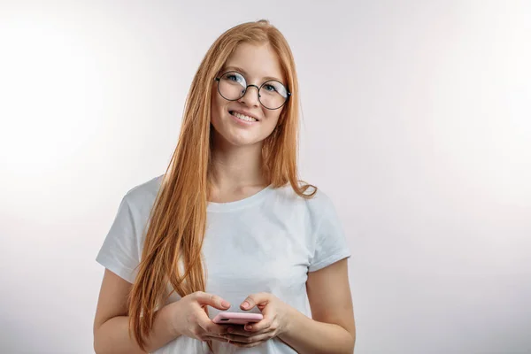 Cheerul pelirroja mujer vestida casualmente trabajando con el teléfono celular — Foto de Stock