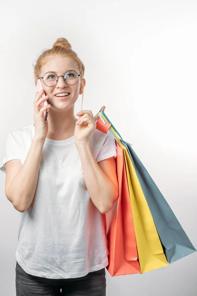 Een opgewonden meisje is het maken van een telefoontje naar haar vriend om te vertellen over haar aankopen — Stockfoto