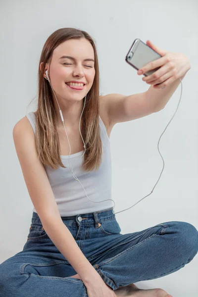 Comic lauging girl robi sobie selfie i pokazuje język przed kamerą — Zdjęcie stockowe
