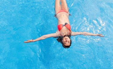 Rahat kız yüzme havuzunda yatıyor.