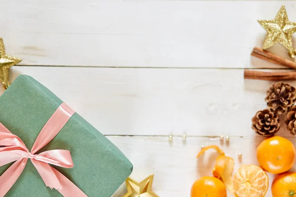 圣诞背景，白色木制桌子上有装饰品和绿色礼品盒 — 图库照片