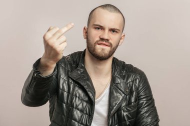 Sakallı genç bir adam terbiyesizlik yapıyor.