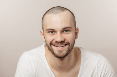 Tıraşsız neşeli adam, güzel mavi gözleri var.