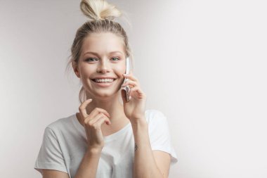 Güzel, gülümseyen sarışın kadın cep telefonuyla konuşuyor. - Yakın çekim. İzole edilmiş.