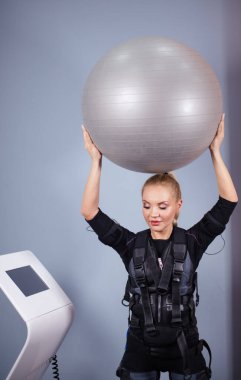 Güzel sarışın zinde kadın EMS eğitmeninin ekranına bakıyor.