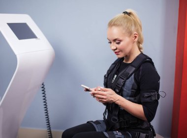 Yakın çekimde, elinde akıllı telefonu olan neşeli bir sarışının fotoğrafı.